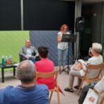 signora coi capelli rossi parla al microfono